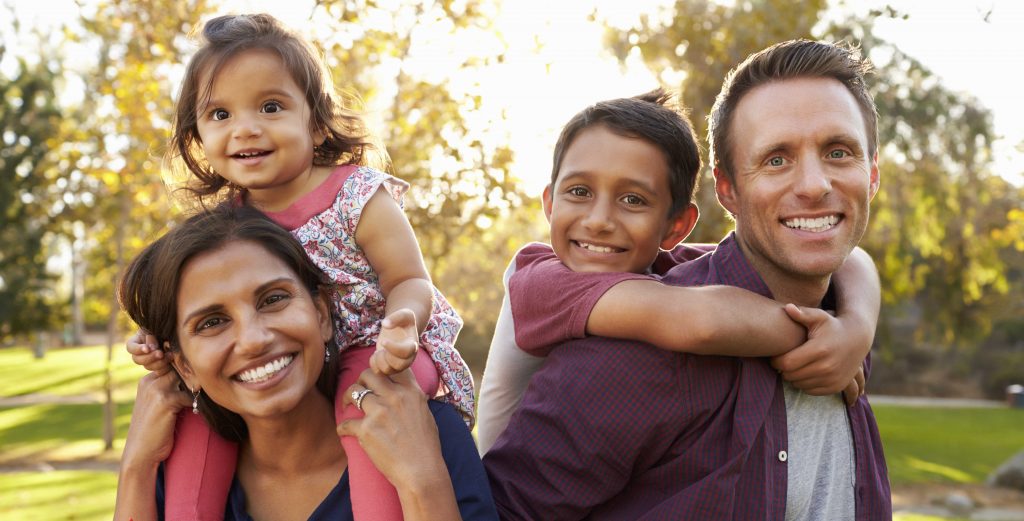 Woman and man with children on their shoulders.