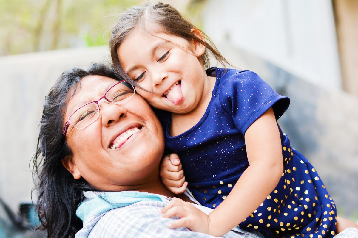 Woman holding child and looking happy.