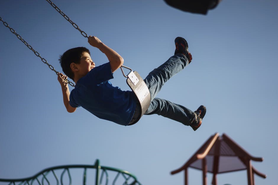 young boy playing on swing