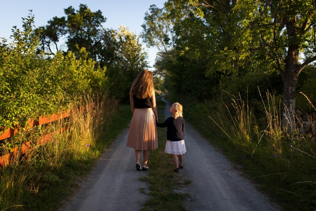 woman and girl walking on trail